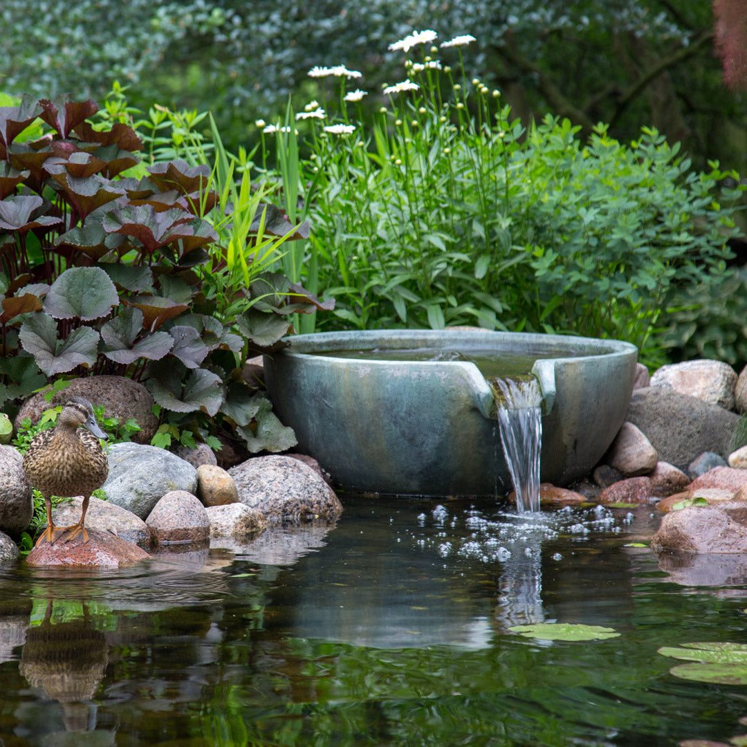 Decorative garden pond with a stone bowl fountain