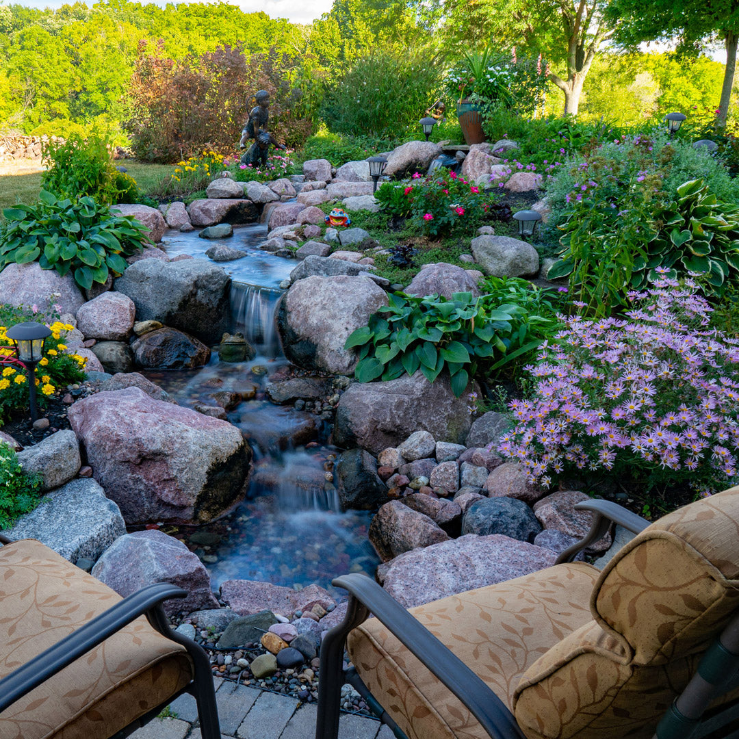 Backyard garden with a small waterfall and stones