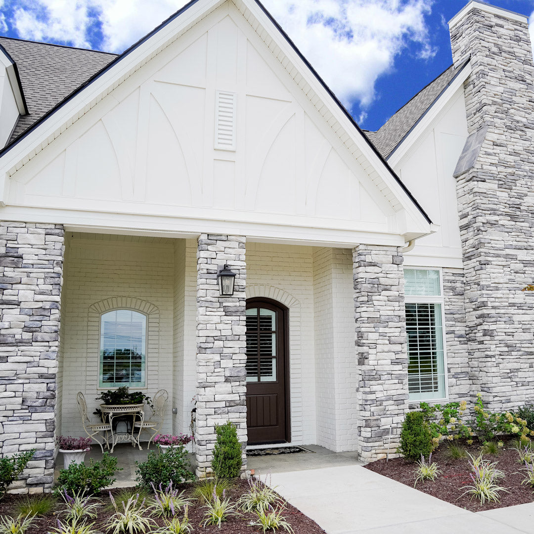 House exterior with stone veneer columns, walls, and chimney